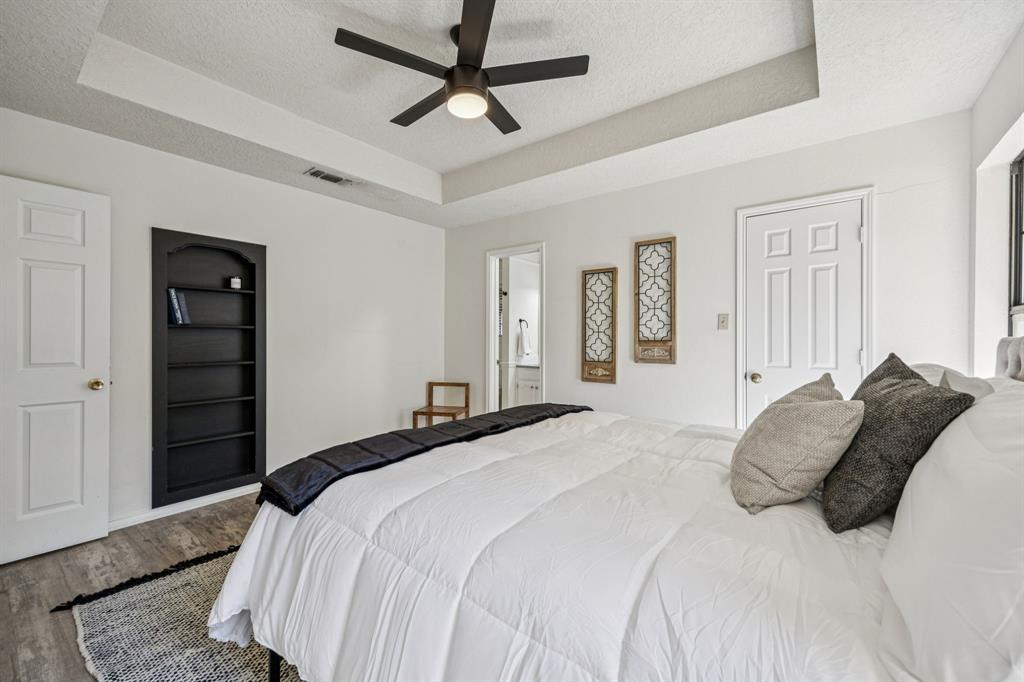 2900 Christopher Drive Denton, TX 76209 - Photo 10 of 25 a bedroom with a bed and a chandelier