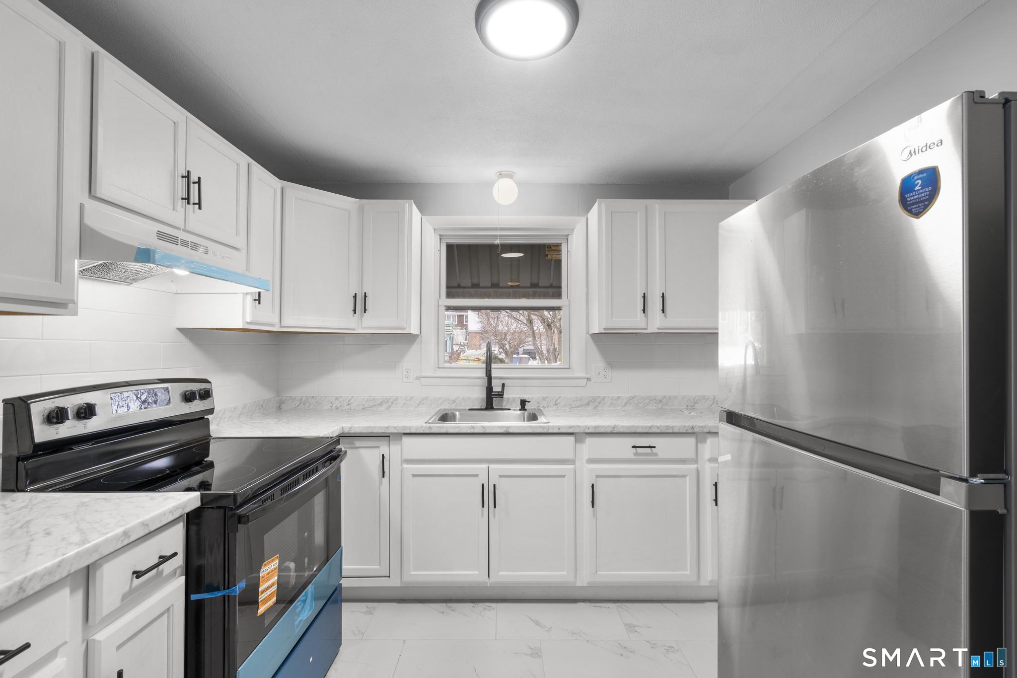 13 Allen Street Bristol, CT 06010 - Photo 13 of 40 a kitchen with white cabinets and appliances