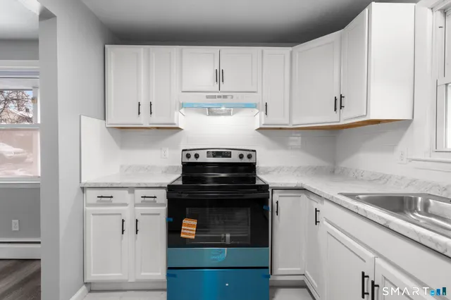 a kitchen with white cabinets and appliances