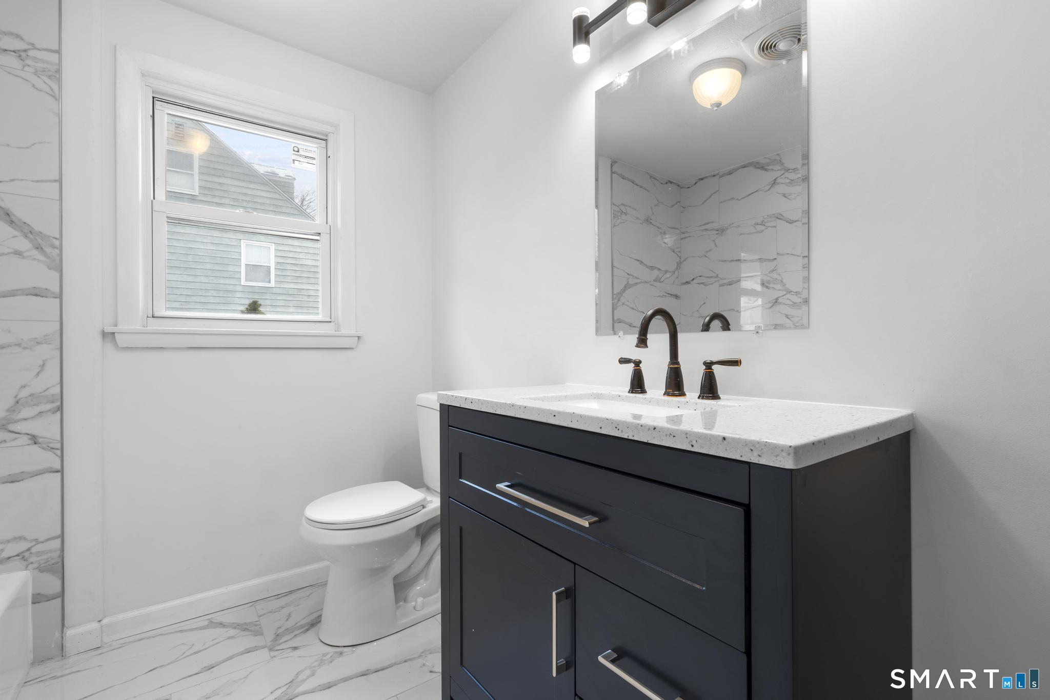 13 Allen Street Bristol, CT 06010 - Photo 16 of 40 a bathroom with a toilet a sink and mirror