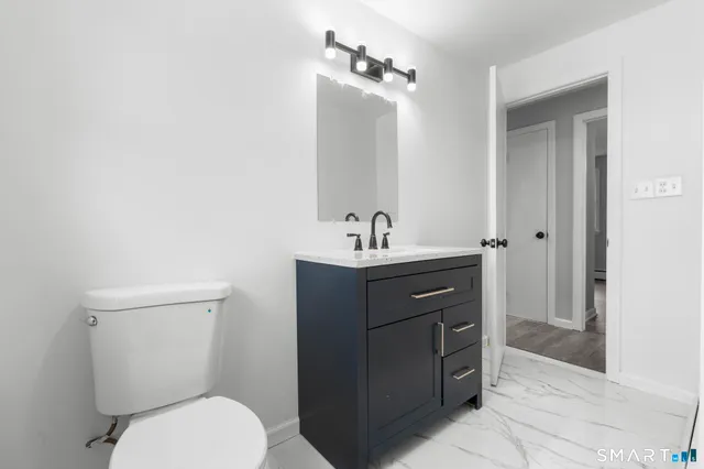 a bathroom with a toilet a sink and mirror