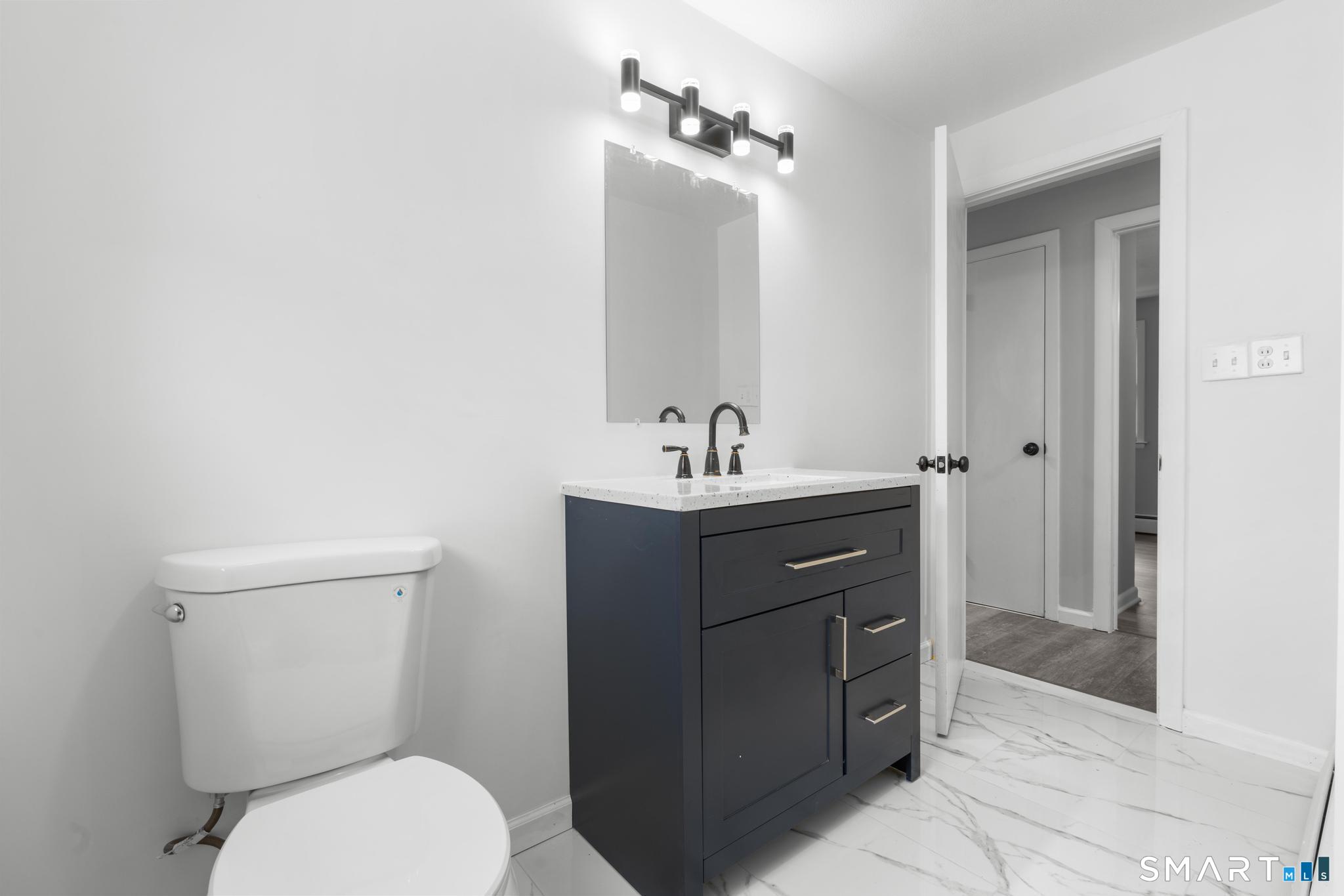 13 Allen Street Bristol, CT 06010 - Photo 17 of 40 a bathroom with a toilet a sink and mirror