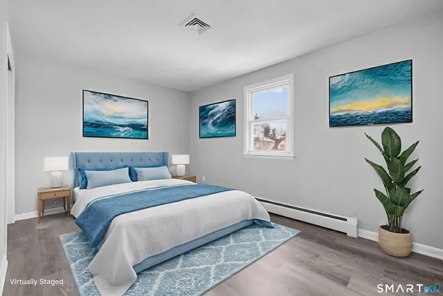 a bedroom with a bed and a painting on the wall