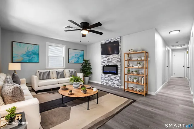 a living room with furniture a fireplace and a flat screen tv