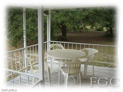 17901 Persimmon Ridge Road Alva, FL 33920 - Photo 6 of 10 a deck with a table and chairs