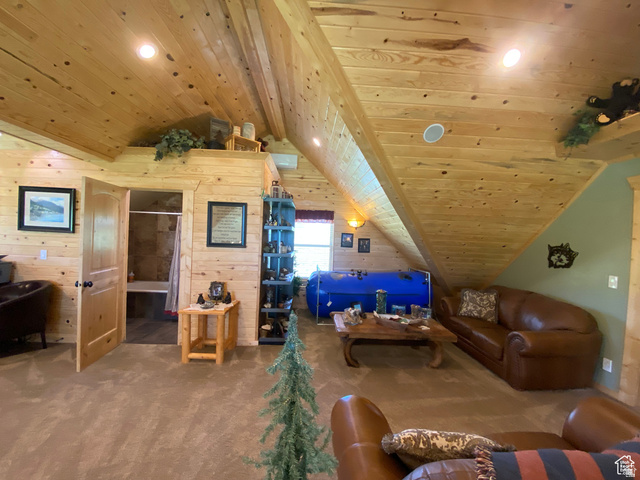 79 Auburn Forest Road Auburn, WY 83111 - Photo 44 of 76 Living area with a wooden ceiling with exposed beams, carpet floors, wooden walls, and recessed lighting