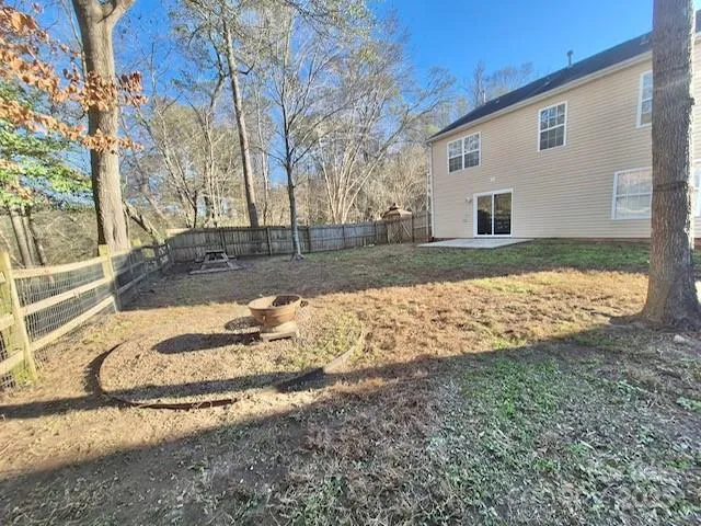 a view of a yard with wooden fence
