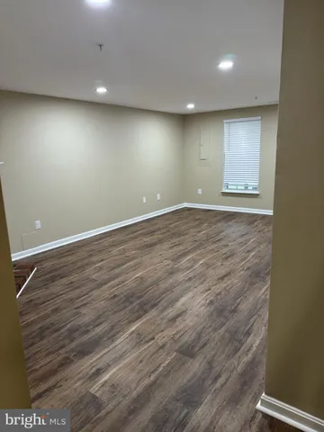 an empty room with wooden floor and entrance