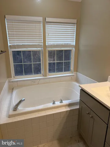 a bathroom with a bathtub and next to a window