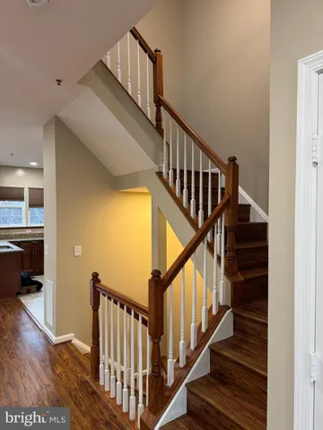 a view of staircase with lots of frames on wall and wooden floor