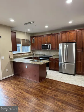 a kitchen with stainless steel appliances granite countertop a stove a refrigerator and a microwave