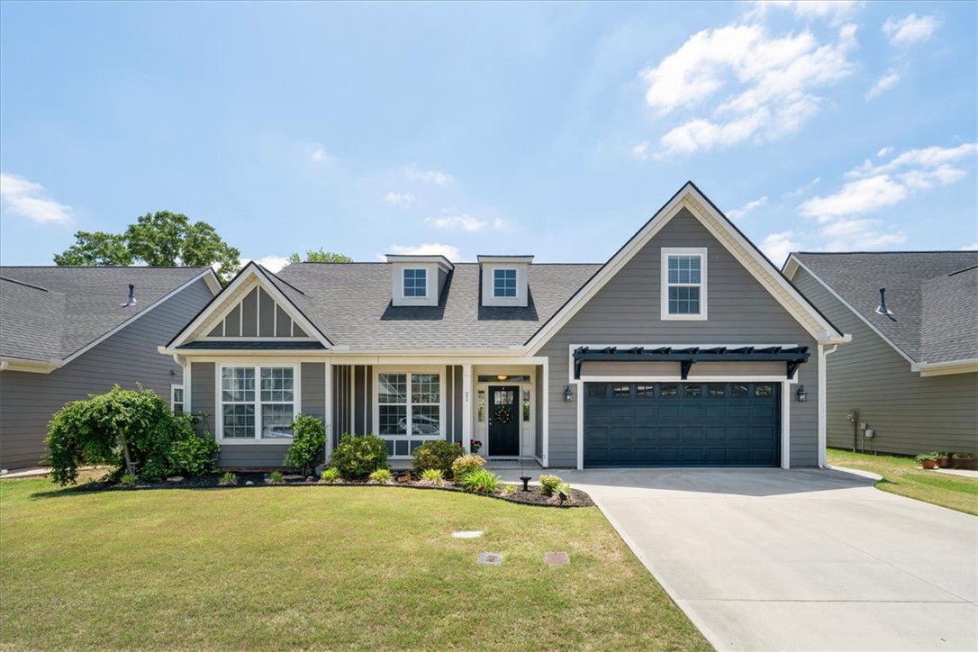 A welcoming facade with dormer windows and an attached garage enhances this home's inviting presence.