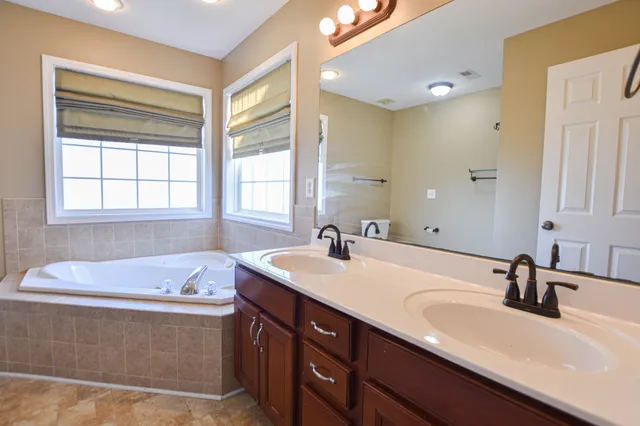 a bathroom with a tub sink and mirror