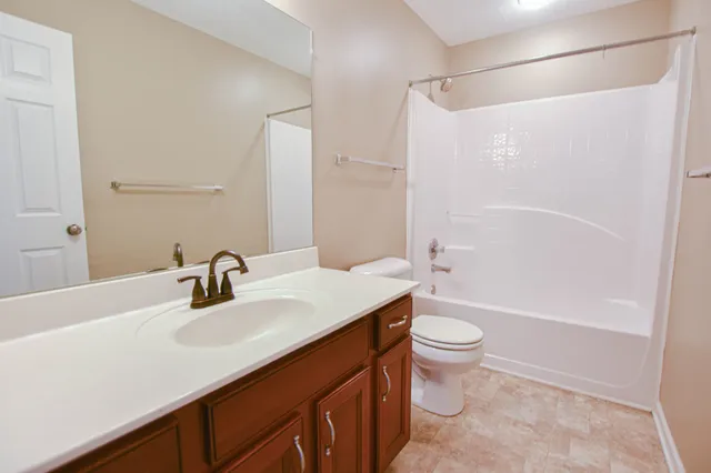a bathroom with a sink a toilet and a large mirror