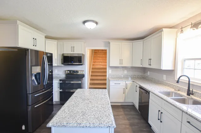 a kitchen with a sink refrigerator and microwave