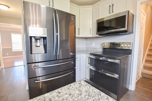 a kitchen with kitchen island granite countertop stainless steel appliances and a sink