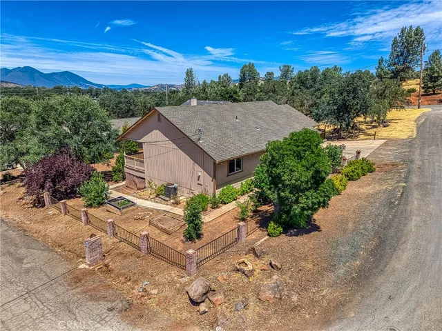 a aerial view of a house with a yard and mountain view in back