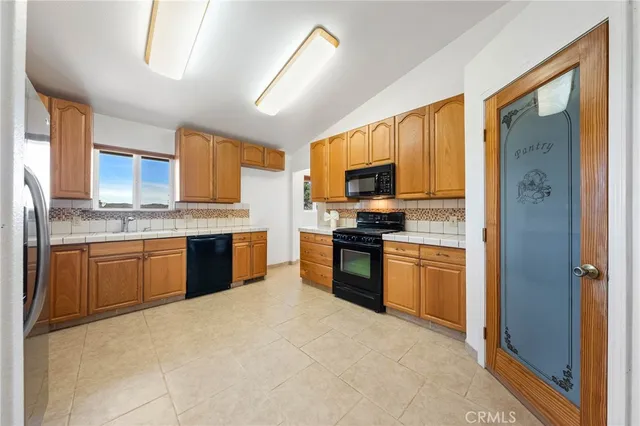 a kitchen with stainless steel appliances granite countertop a refrigerator sink and stove