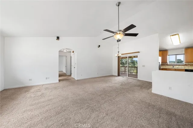 a view of a livingroom with a ceiling fan and window