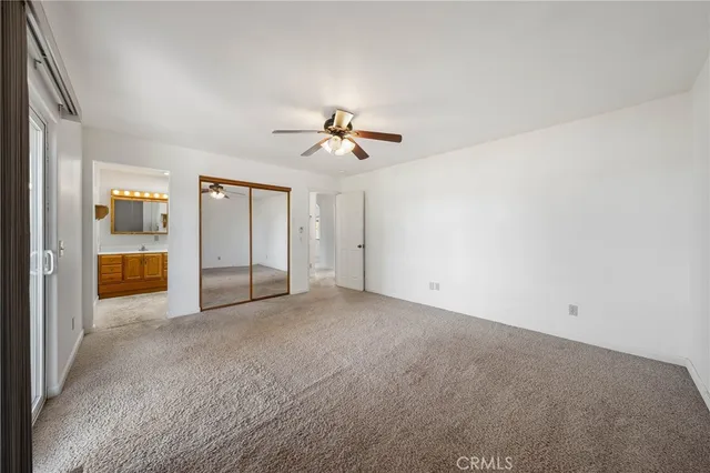 an empty room with fan and glass door