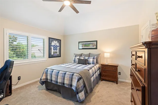 a bedroom with a bed next to a window and a flat screen tv