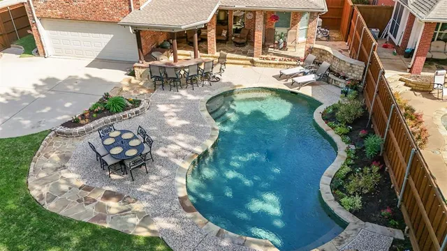 an aerial view of a swimming pool with outdoor seating