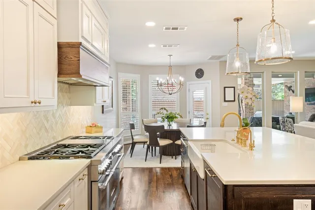 a large kitchen with kitchen island a large counter top space a sink stainless steel appliances and cabinets