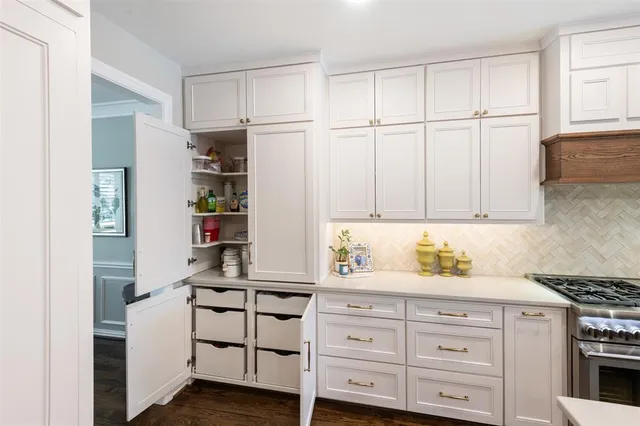 a kitchen with stainless steel appliances white cabinets and a refrigerator