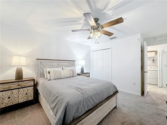 a bedroom with a bed and a lamp on the dresser