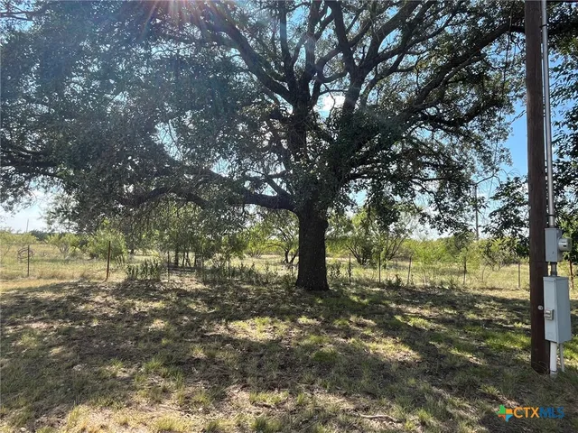 an empty room with kitchen view and a fireplace