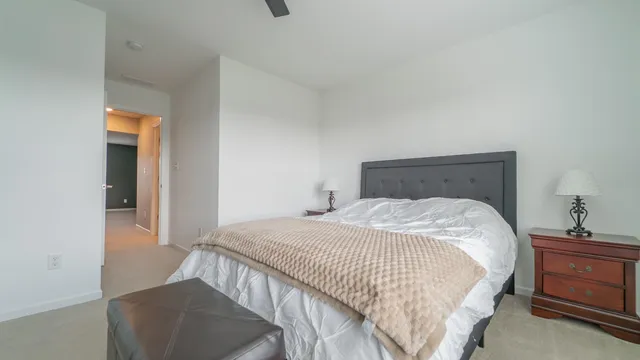 a bedroom with a bed and a lamp on dresser