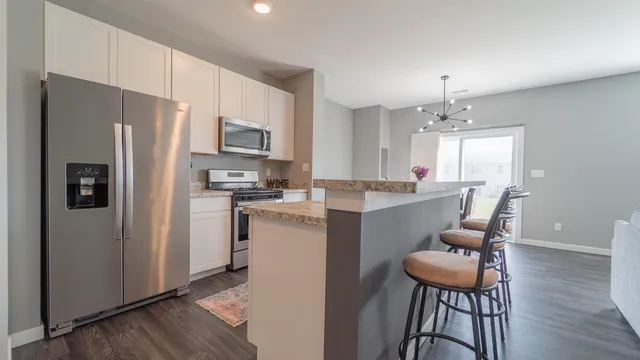 a kitchen with a refrigerator a sink dishwasher a stove and a refrigerator with wooden floor