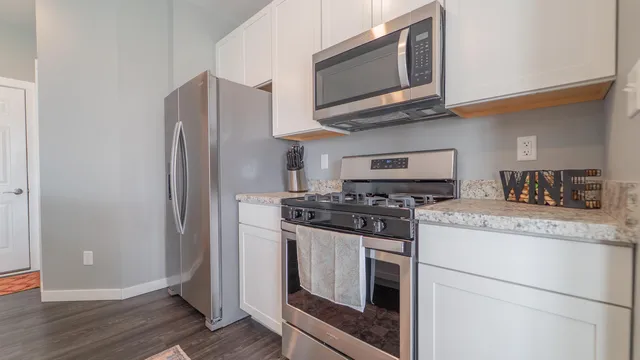 a kitchen with stainless steel appliances granite countertop a stove microwave and refrigerator