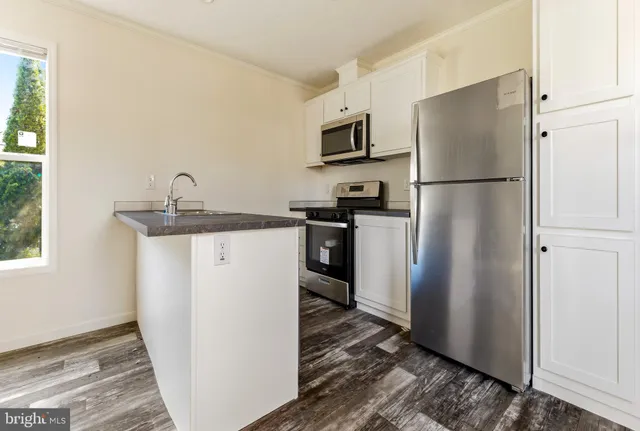 a kitchen with stainless steel appliances granite countertop a refrigerator a sink a stove a microwave and island