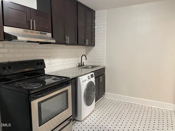a kitchen with granite countertop white cabinets and black appliances