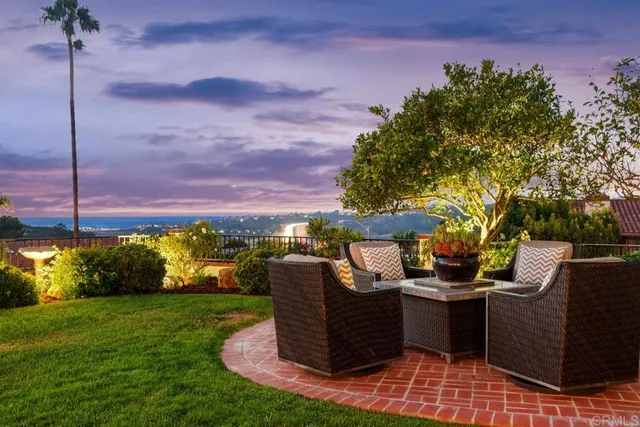 a view of a patio with couches potted plants and a big yard
