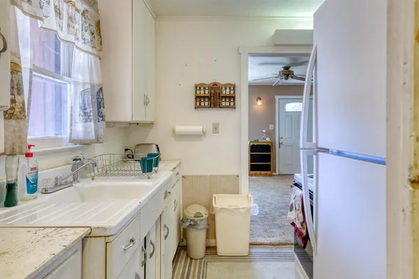 a kitchen with a sink refrigerator and cabinets