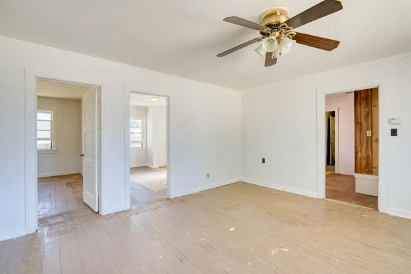 wooden floor in an empty room and a ceiling fan