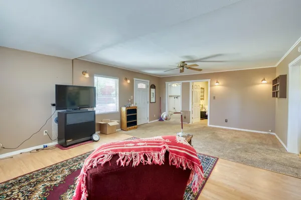 a spacious bedroom with a bed and a flat screen tv