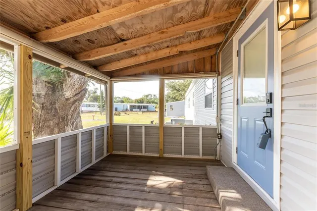 a view of an empty room with wooden floor and windows