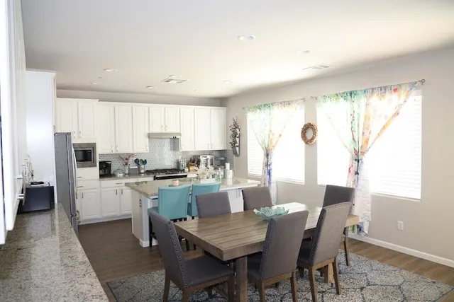 a kitchen with refrigerator cabinets dining table and chairs