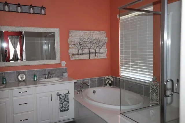 a bathroom with a tub a sink and mirror