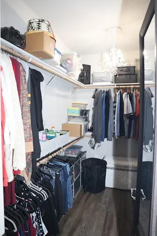a view of walk in closet with clothes and shoes