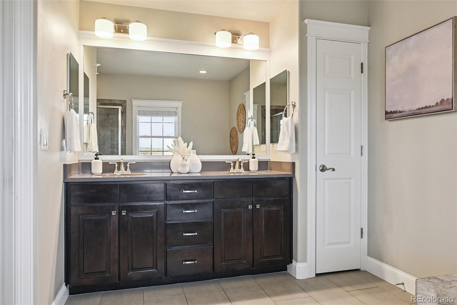 8741 East 33rd Avenue Denver, CO 80238 - Photo 22 of 43 a bathroom with a granite countertop sink two mirror and a