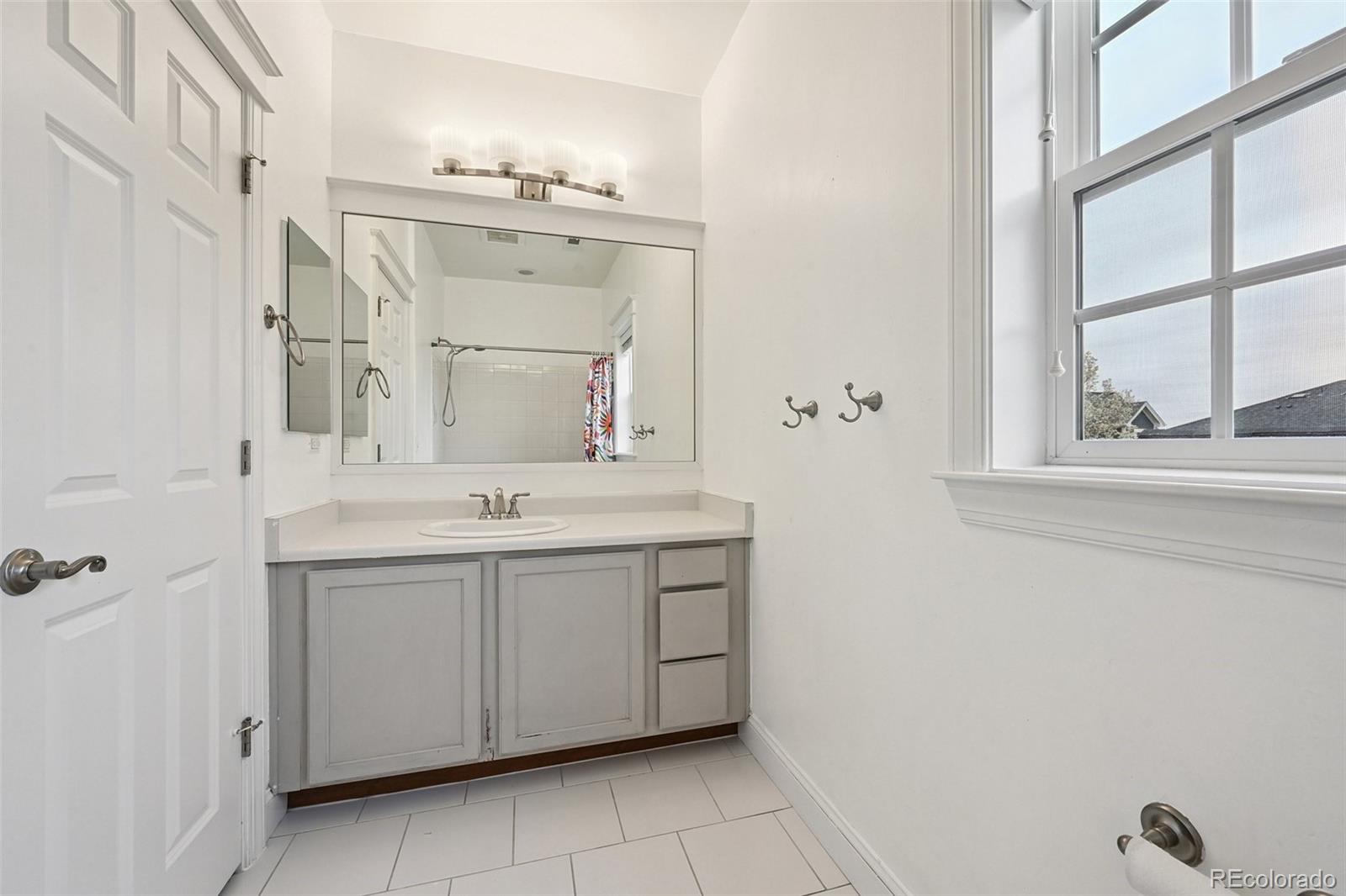 8741 East 33rd Avenue Denver, CO 80238 - Photo 28 of 43 a bathroom with a double vanity sink and a mirror