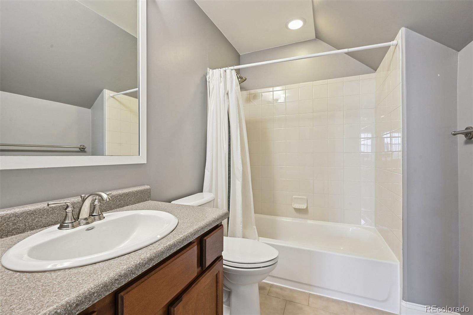 8741 East 33rd Avenue Denver, CO 80238 - Photo 30 of 43 a bathroom with a granite countertop sink toilet and shower