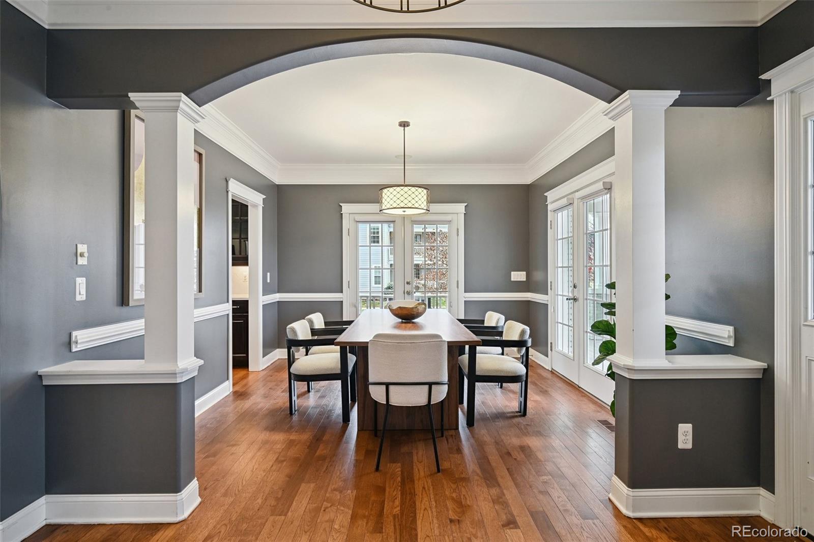 8741 East 33rd Avenue Denver, CO 80238 - Photo 3 of 43 a dining room with wooden floor a chandelier a glass table and chairs