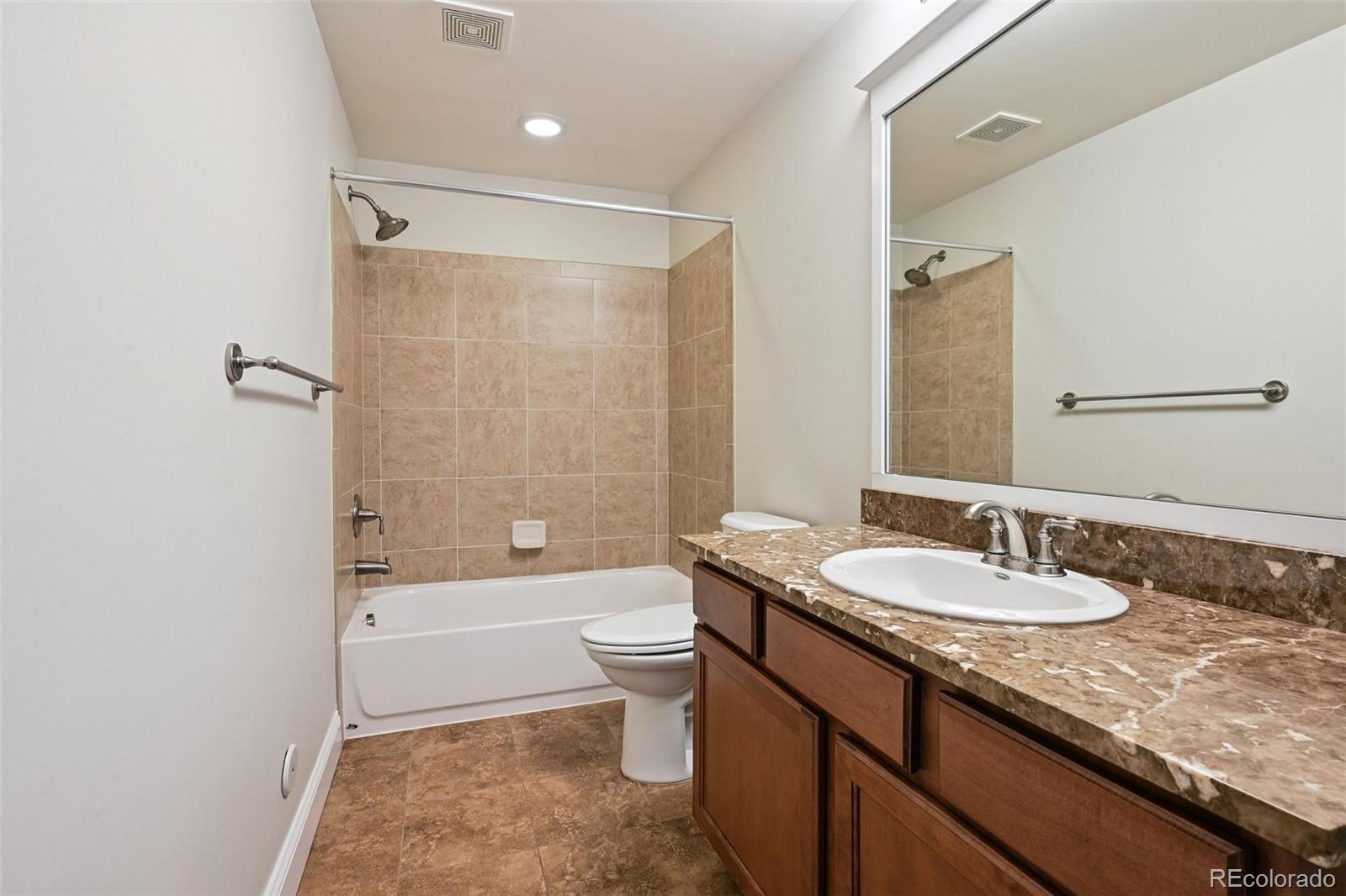 8741 East 33rd Avenue Denver, CO 80238 - Photo 34 of 43 a bathroom with a granite countertop sink toilet and shower