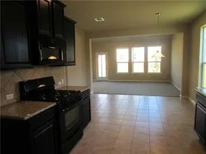 a kitchen with granite countertop a stove a sink and a microwave