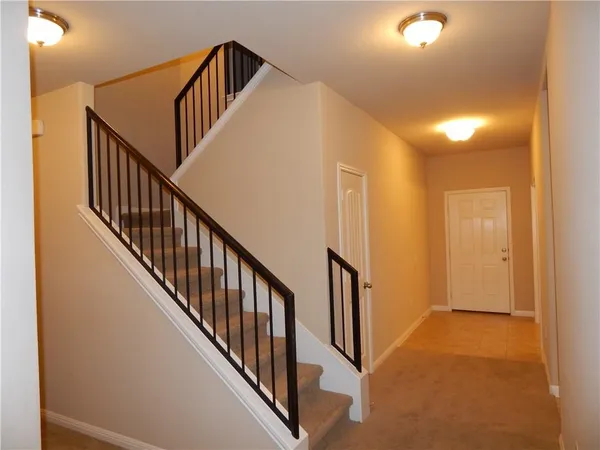 a view of staircase with railing and a chandelier